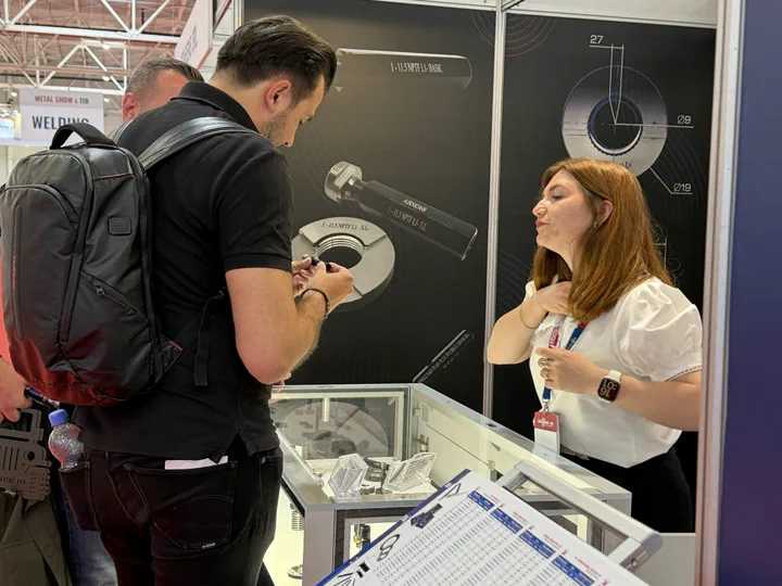 Expozantă prezentând piese prelucrate unui vizitator